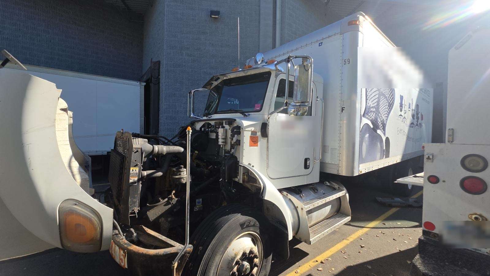 Box truck front end torn down for repair at a loading dock