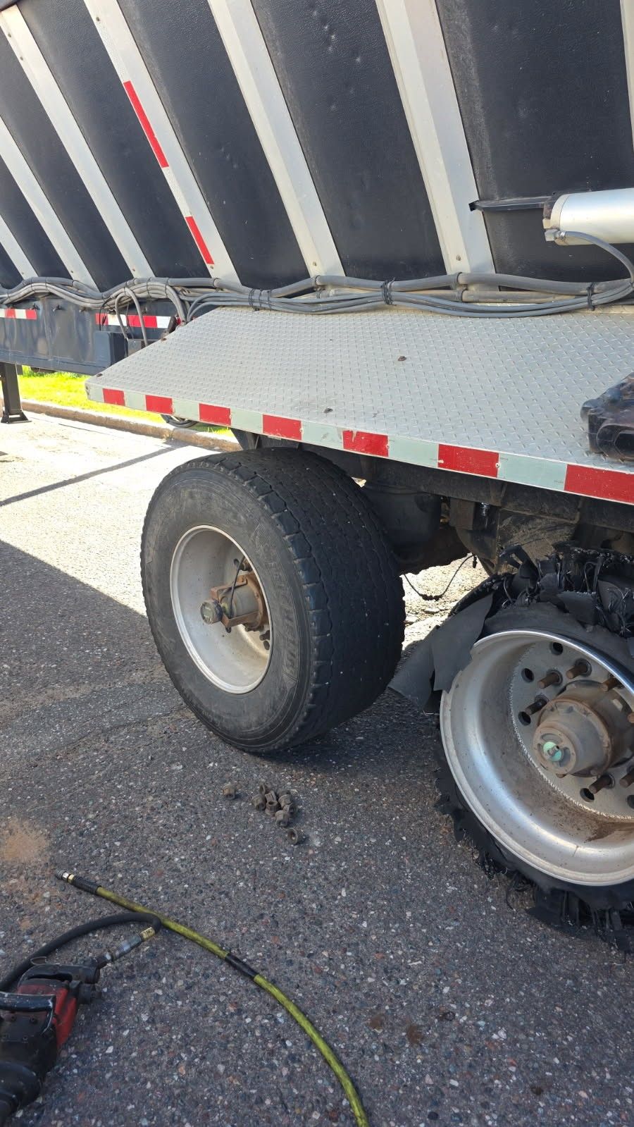 Roadside tire service on a dump trailer with an impact gun