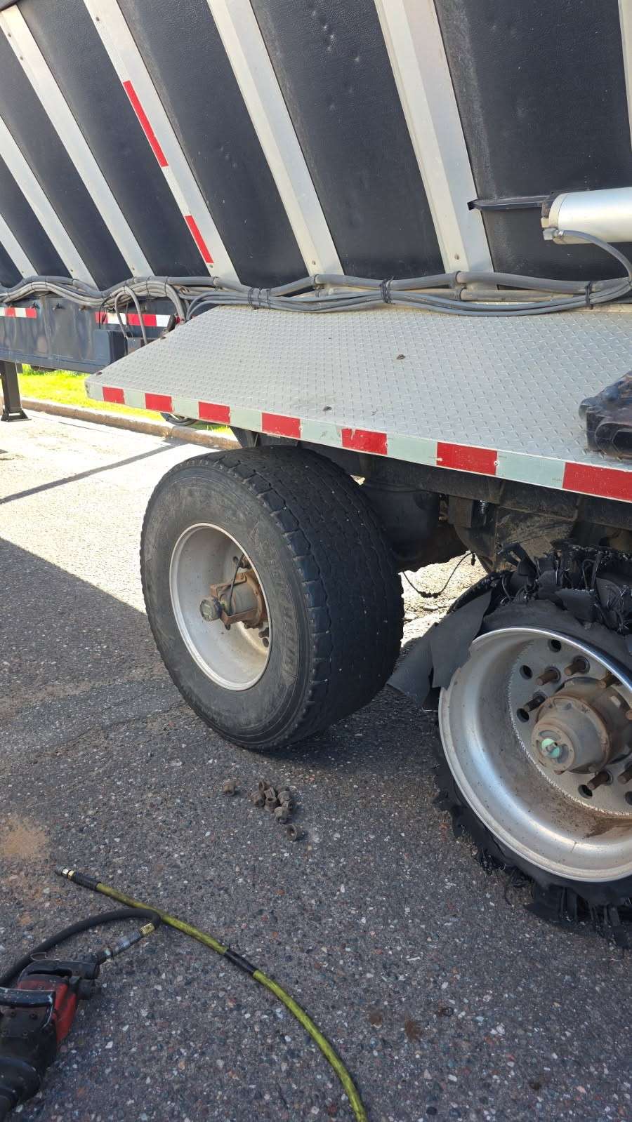 Roadside tire service on a dump trailer with an impact gun