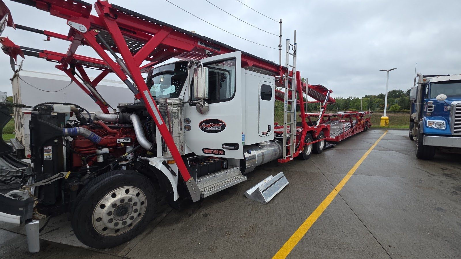 Car hauler semi truck with the hood open for on-site repair