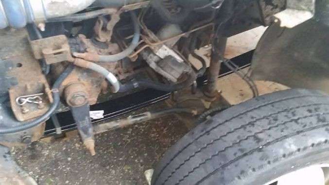 Steer axle and suspension components exposed for repair